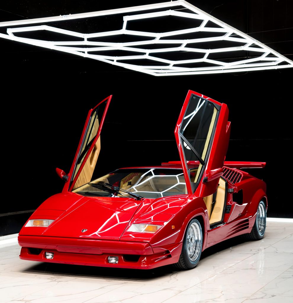 Lamborghini Countach in red with scissor doors open under hex lighting
